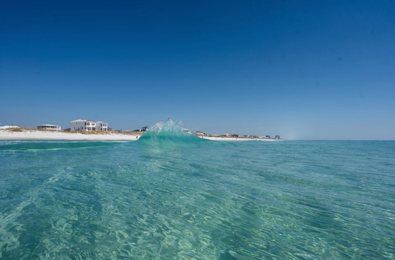 Soft light reflecting on waves below a coastal lighthouse.